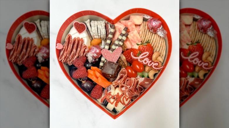 hert-shaped box of deli meats, cheeses, and other snack items