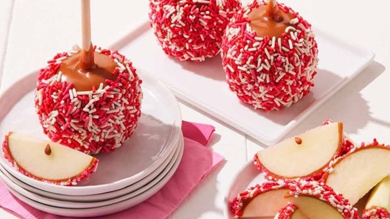 caramel apples coated in red, white, and pink sprinkles