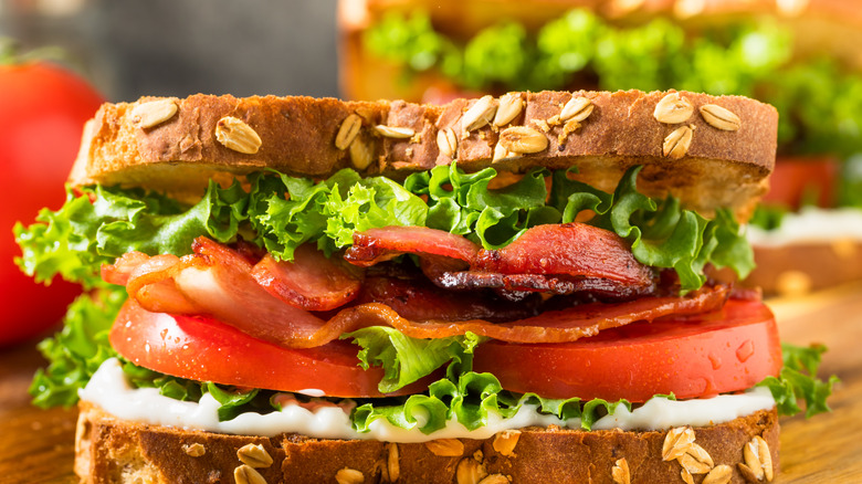 Up-close view of a bacon, lettuce, and tomato sandwich on whole grain bread