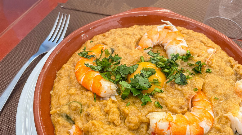 Traditional Portuguese shrimp bread stew (açorda de camarão) served in a casual snack bar setting