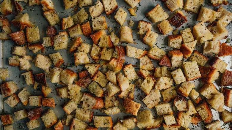 cubes of stale bread on baking sheet ready to bake into croutons