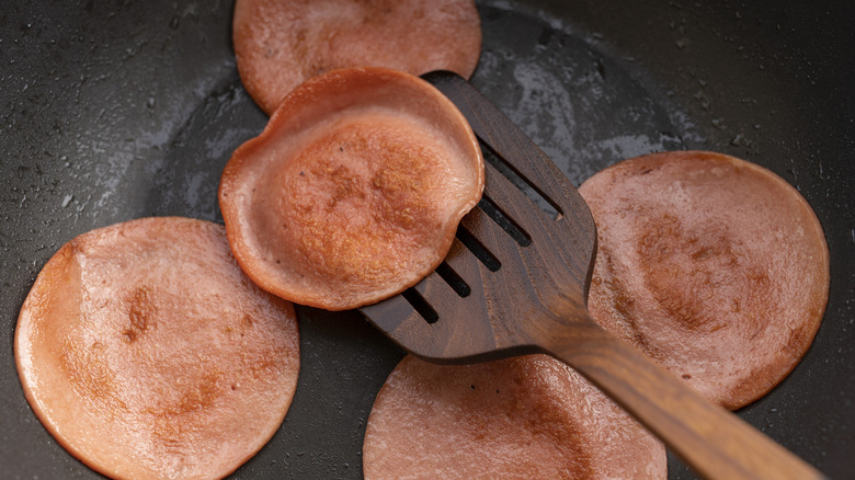 Bologna being fried in a pan