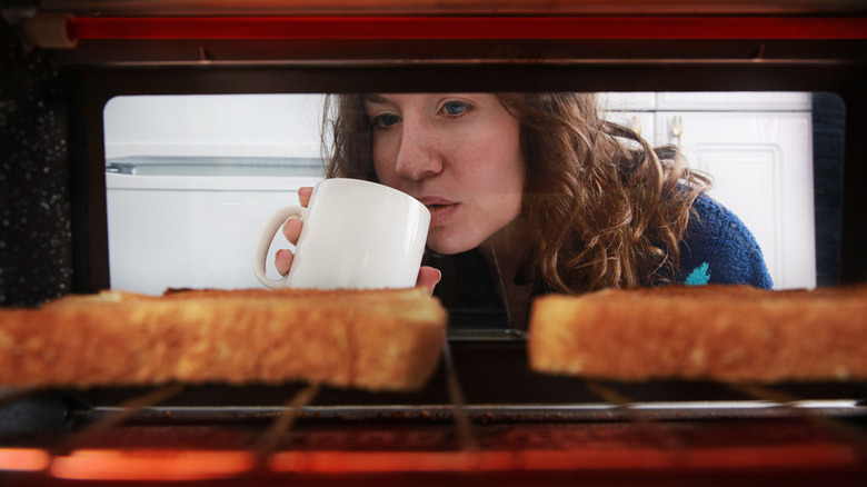 Woman looking into a toaster oven