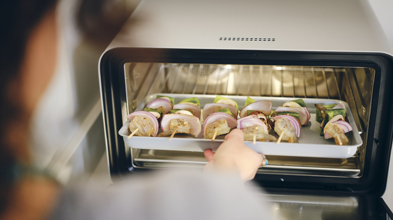 Person making kebabs in a toaster oven