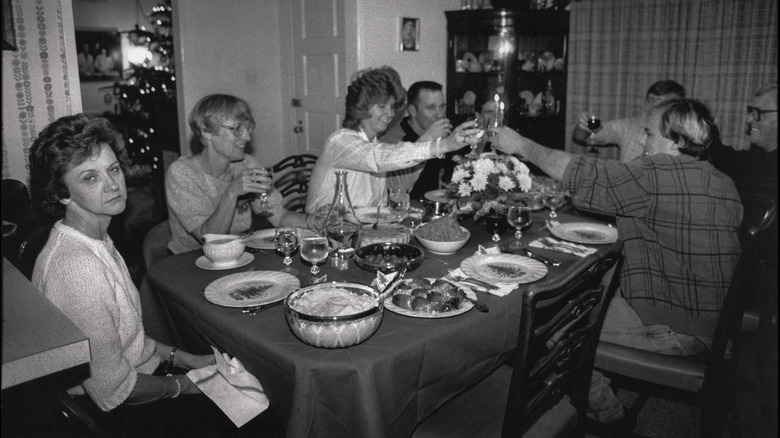Family and friends eat dinner in the 1980s