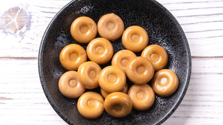 A black dish of butterscotch hard candies.