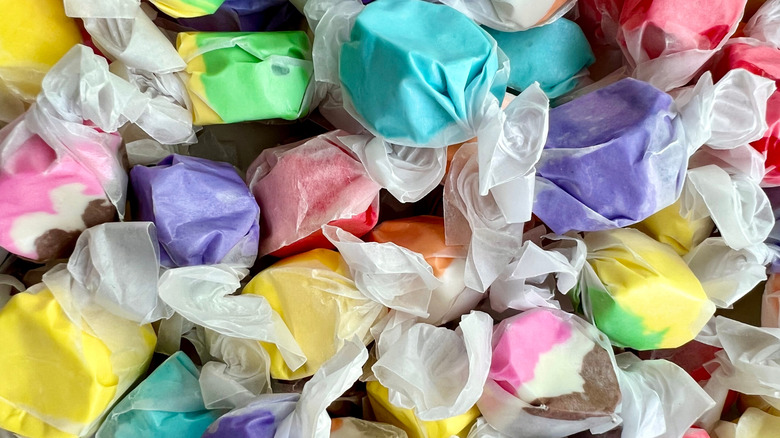 Close up of wrapped pieces of salt water taffy in assorted flavors and colors.