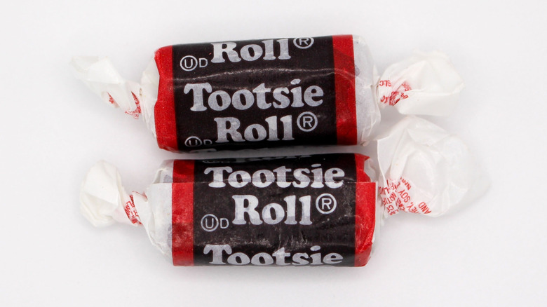 Two Tootsie Roll candies on white background