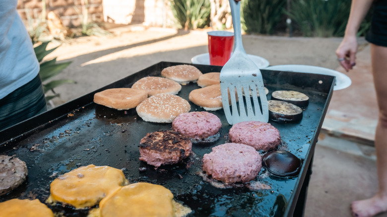 Spatula poking at burger on grill