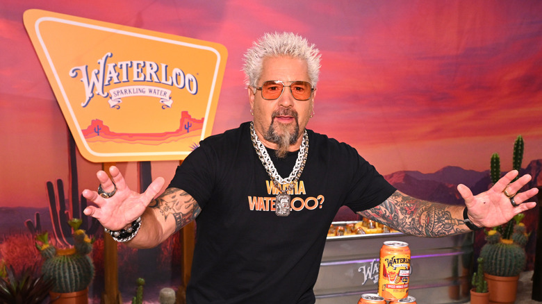 Guy Fieri in tinted sunglasses and a thick chain necklace