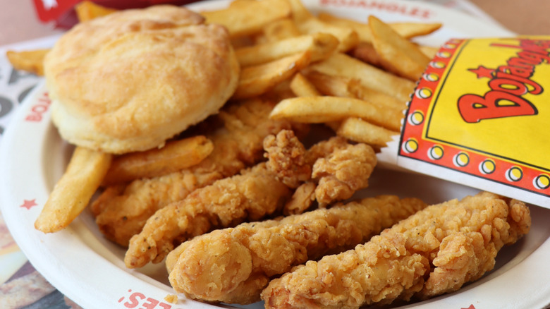 Bojangles chicken fingers, fries, and a biscuit on a paper plate