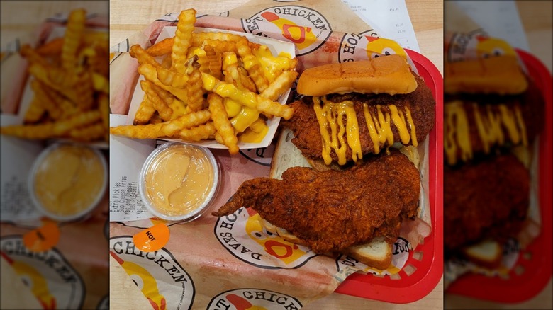 Order of Dave's Hot Chicken tenders with fries, bread, and sauce on a tray