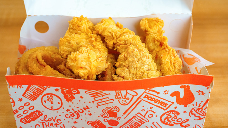 Box of Popeyes chicken tenders with onion rings
