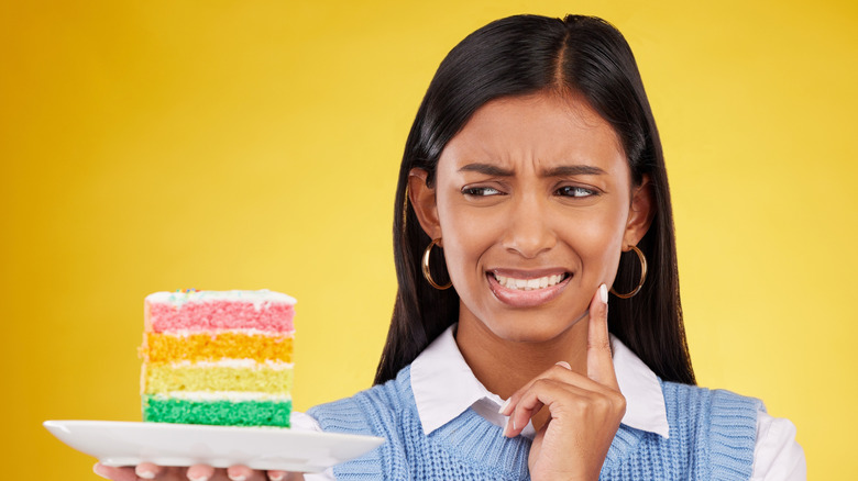 Woman looking at dessert with an unsure expression