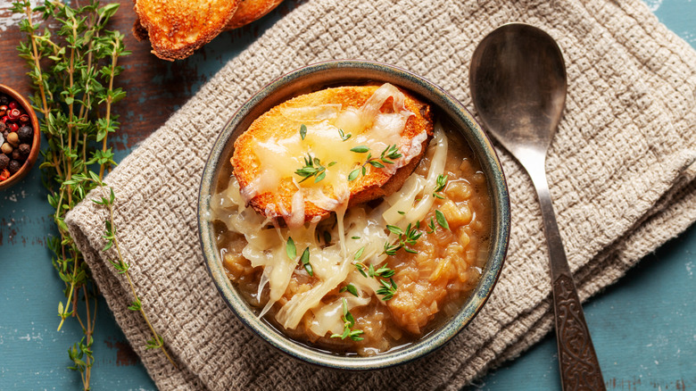 Classic French onion soup baked with cheese croutons sprinkled with fresh thyme