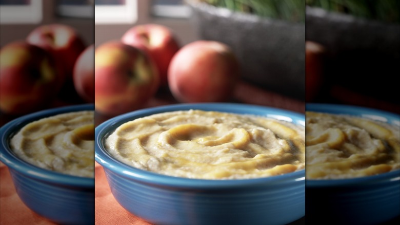 Bowl of grits with apples in background