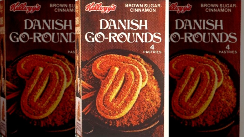 A box of brown sugar-cinnamon Danish Go-Rounds; brown box with a photo of two flat, spiral-shaped pastries atop a dish of brown sugar and a few cinnamon sticks