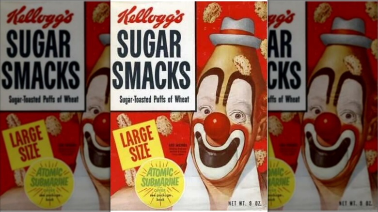 A box of vintage Sugar Smacks cereal; A smiling clown with an cone-shaped head wearing a tiny gray hat is on the right; pieces of cereal seem to be flying through the air