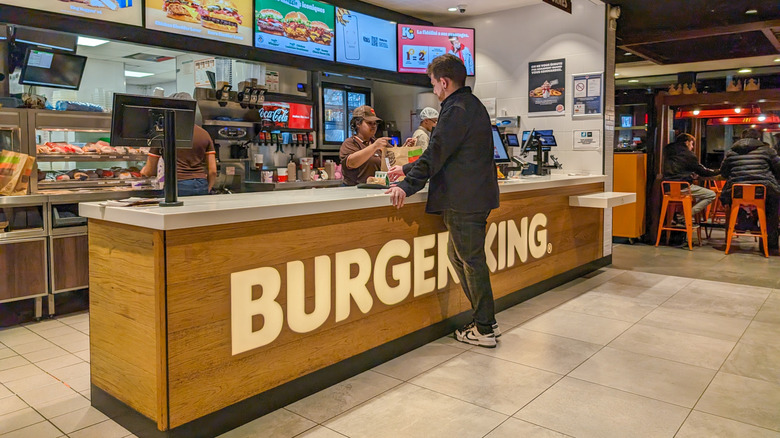 A man ordering food at a Burger King counter