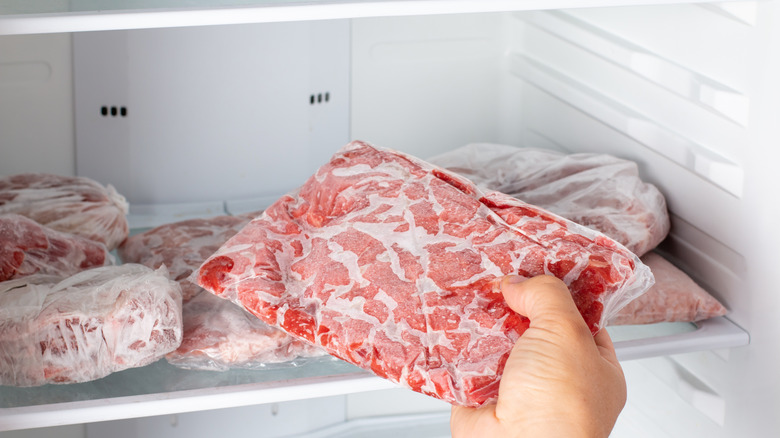 Man taking out frozen meat from freezer