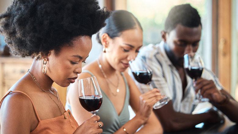 Three people sniffing wine during wine tasting