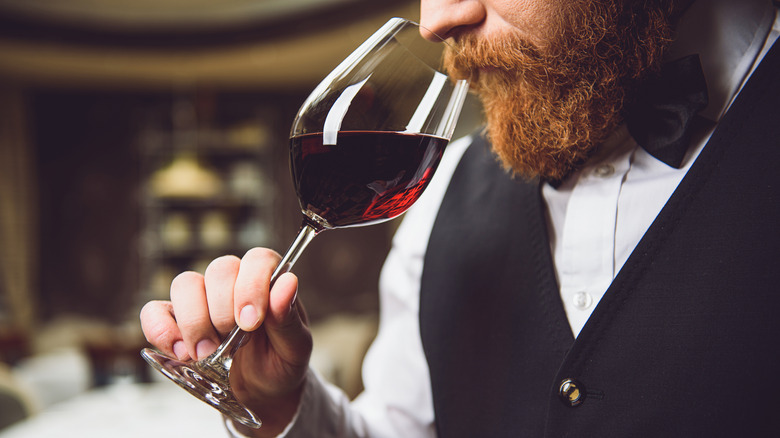 Bearded man sniffing wine