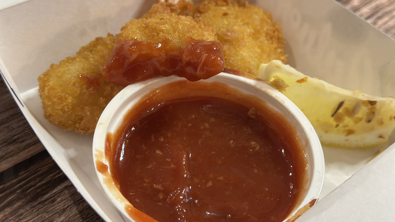 Culver's 3 Piece Butterfly Jumbo Shrimp with cocktail sauce, one has a bite taken out of it