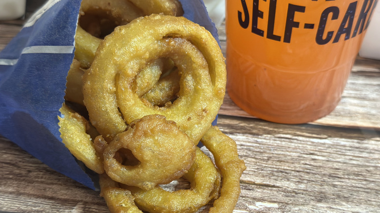 Culver's Medium Onion Rings in bag with drink on the side