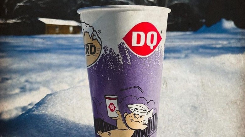 A Dairy Queen Blizzard sitting in the snow, with Dennis the Menace on the cup