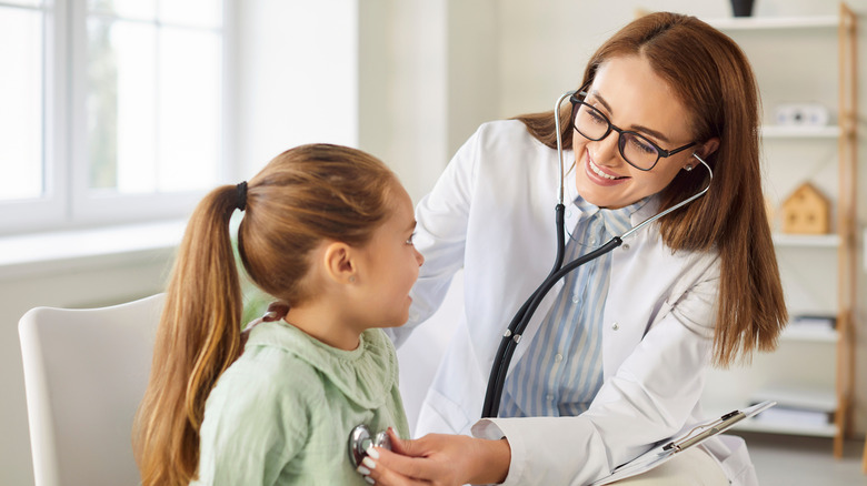 A pediatrician checking a child's lungs