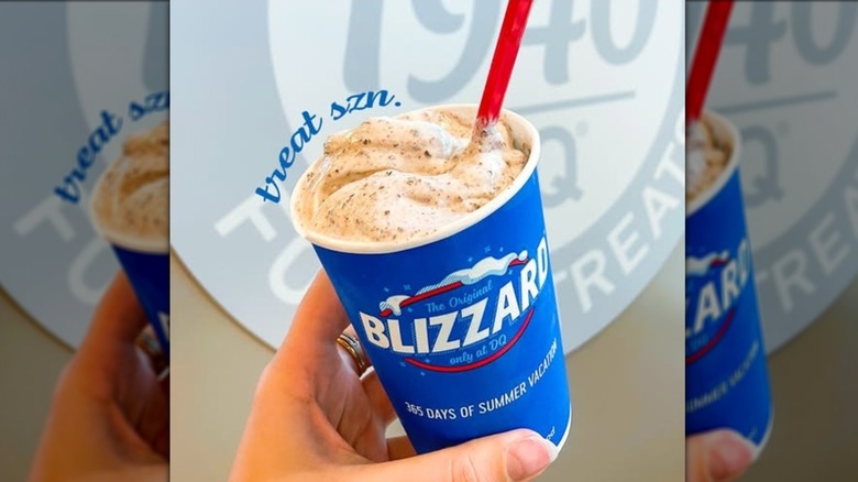 Hand holding a Turtle Pecan Cluster Blizzard, mirrored