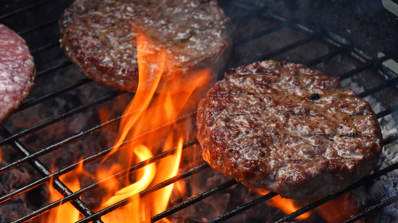 Burgers on a grill with a flame