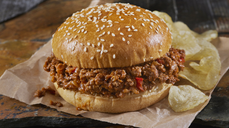 A sloppy Joe and chips on a table