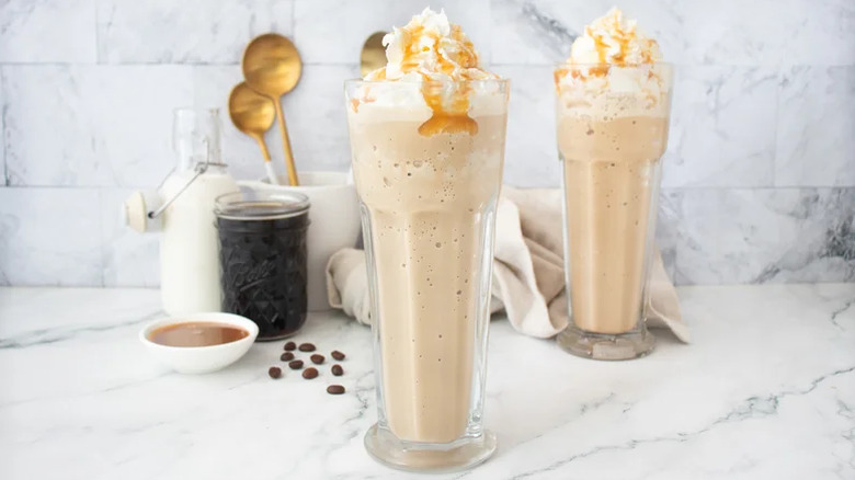 A pair of caramel frappes on a countertop