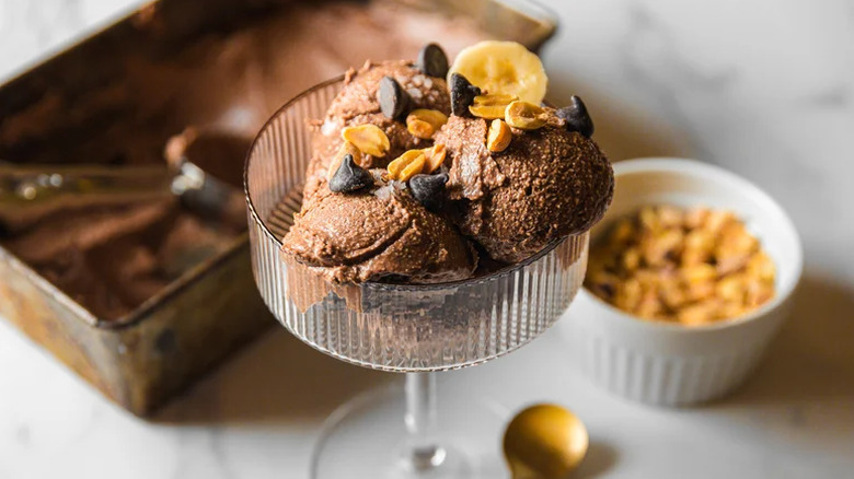 chocolate ice cream with peanuts and banana in a glass dish