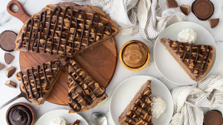 Peanut butter chocolate ice cream cake on wooden board and slices on plates