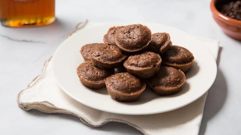 Chocolate pancake bites on a plate resting on a napkin and placed on a table