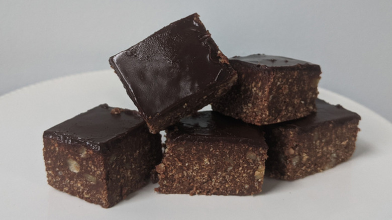 A plate of no-bake brownies against a grey background