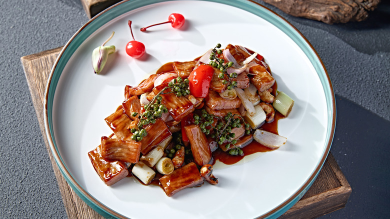 Plate of stir fry pork and sauce on a table