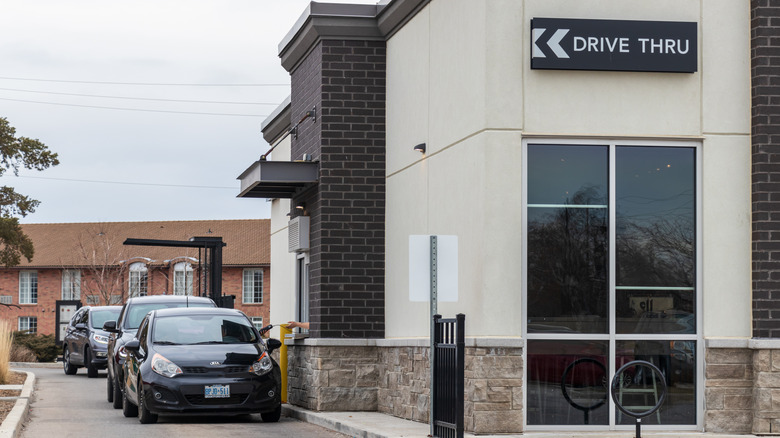 A drive-thru at a Starbucks with a line of cars on an overcast day