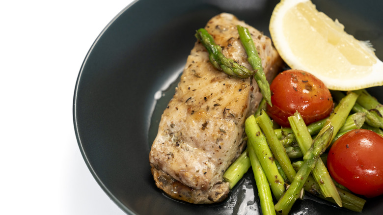 Red snapper steak with asparagus, tomatoes, and lemon