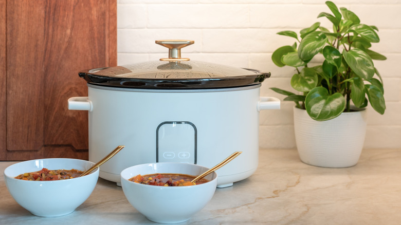 Slow cooker with two bowls in front of it