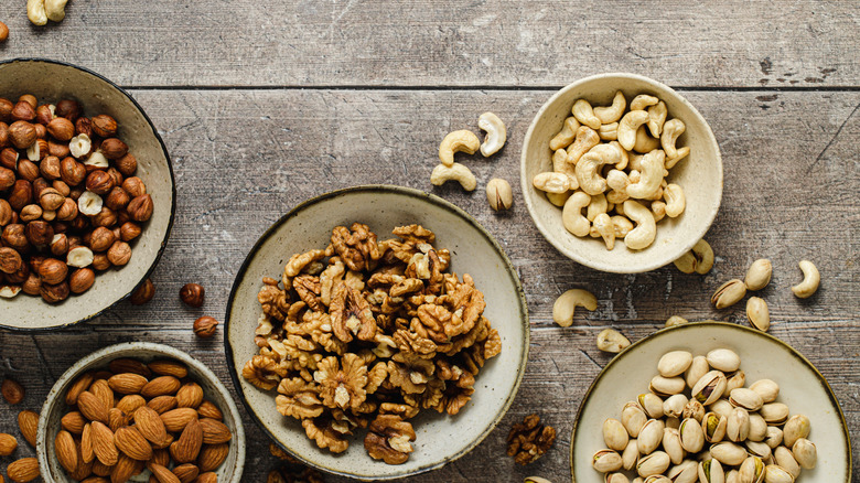 Bowls of assorted nuts on a distressed wooden table