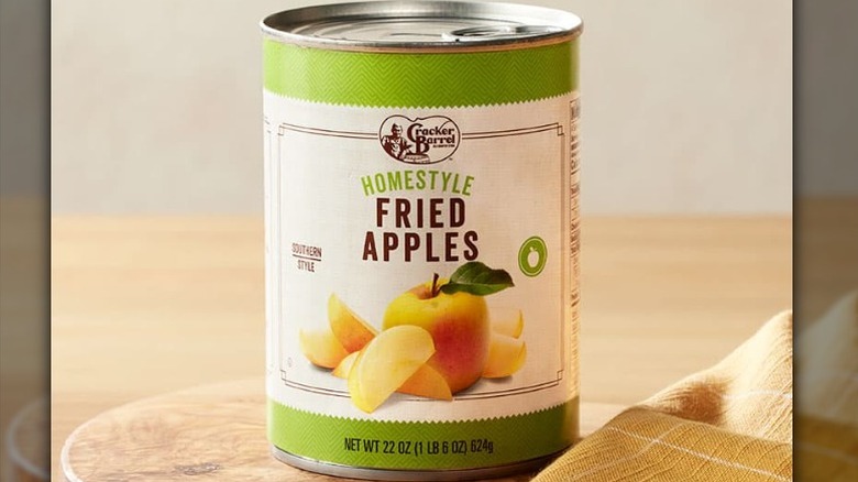 A can of Cracker Barrel homestyle fried apples with a green and white label on a wooden table