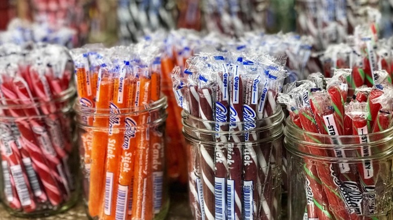 Mason jars filled with Gilliam candy sticks in orange, grape, strawberry, and other flavors