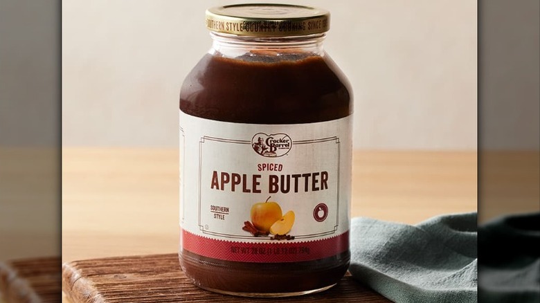A jar of Cracker Barrel spiced apple butter with red and white label on a wooden countertop