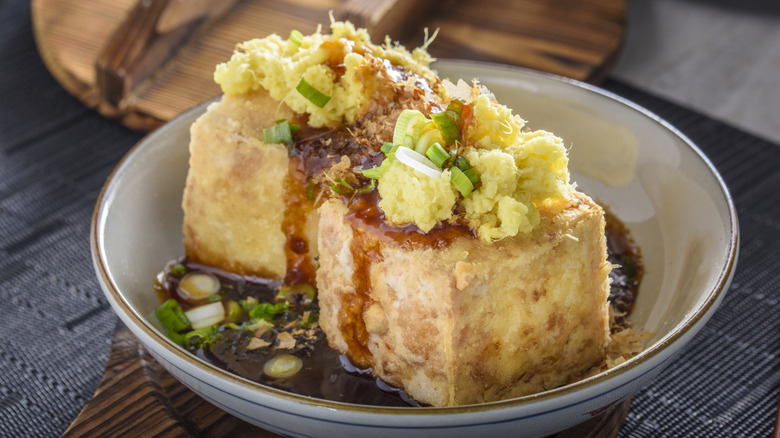 Cubes of agedashi fried tofu with ground radish in a bowl