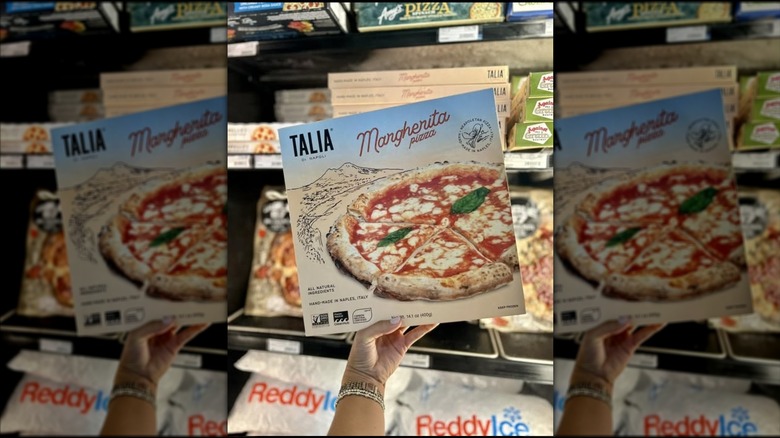 Someone holding a Talia di Napoli frozen pizza inside a store, mirrored