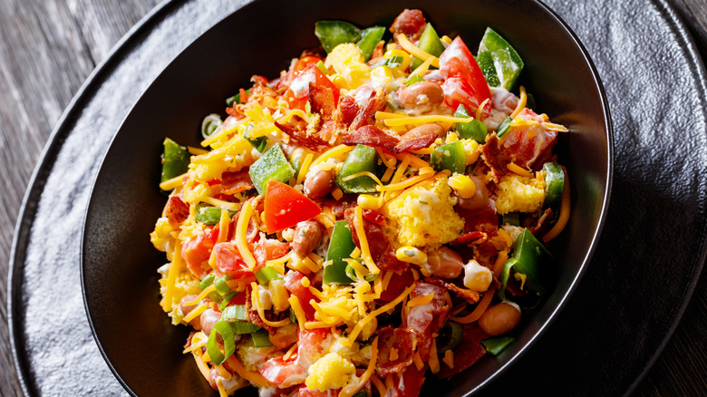 A black dish of cornbread salad