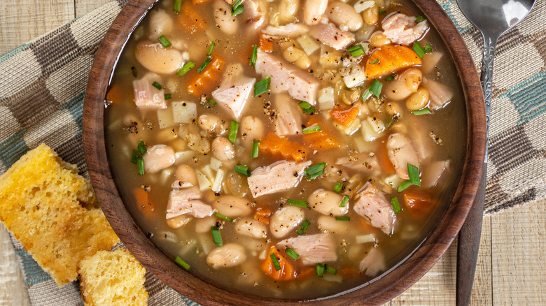 A bowl of soup and cornbread slices
